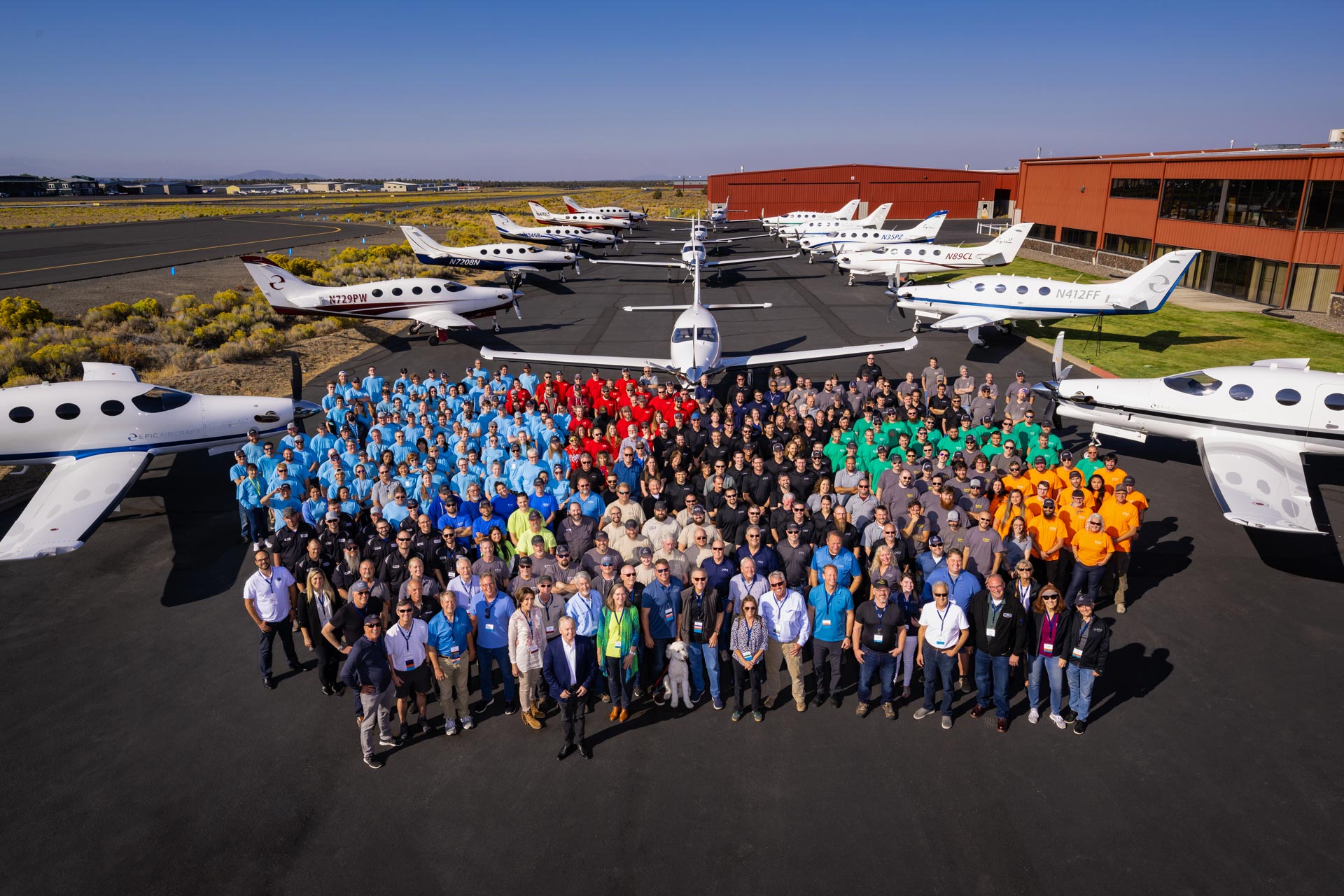 Many Epic Aircraft employees standing in front of E1000 GX airplanes
