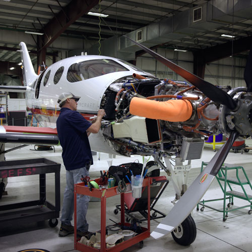 Worker inspecting engine of airplane